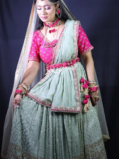 A full-length shot of the client's mint green lehenga, highlighting the floral belt and tassels.