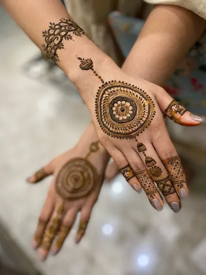 A minimalist mandala design, perfect for someone who wants a touch of henna without full coverage. The central mandala is connected to the finger with a delicate chain of dots.