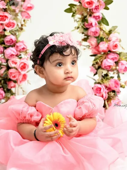 A princess on her floral swing. Surrounded by pink roses and sitting on a bed of clouds, this is a true fairytale moment captured forever.