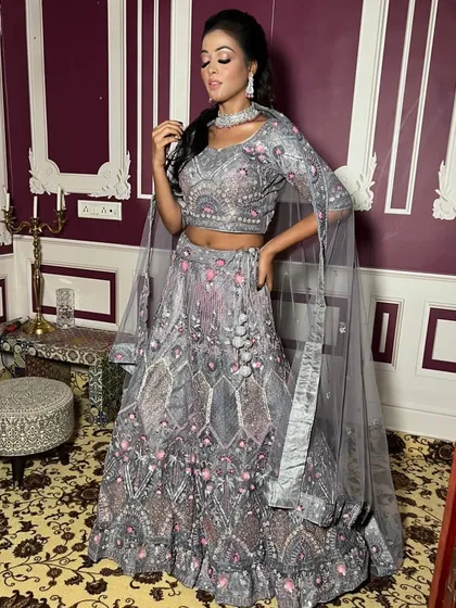 This client looks stunning in a grey lehenga with delicate pink and silver embroidery. The cape-style dupatta adds a modern and graceful touch to the ensemble.