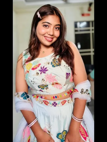 This smiling portrait captures the cheerful and youthful vibe of the hand-painted pastel lehenga. It's a perfect rental for a fun and festive occasion.
