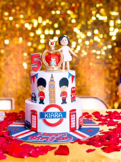A beautiful shot of the London cake against a sparkling gold backdrop, surrounded by red rose petals.