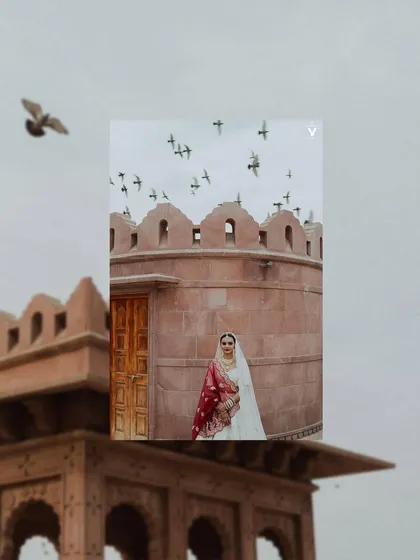 An artistic composition with the bride framed by the architecture of a Jodhpur palace, with birds flying overhead. This shot feels grand, poetic, and full of stories.