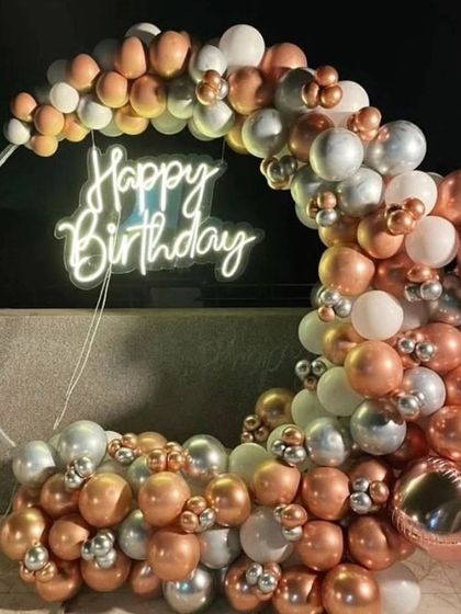 An elegant rooftop balloon decoration in rose gold and silver. This semi-arch is perfect for creating a sophisticated photo spot for a birthday party.