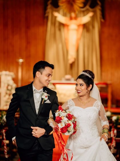A happy candid of the couple walking down the aisle after their church ceremony. The warm lighting of the church and their smiles make this a cherished memory.