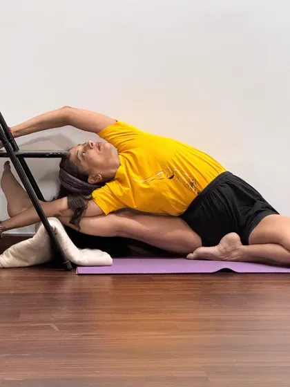 This supported variation of Parighasana (Gate Pose) uses a chair to assist with the lateral stretch. The prop helps to maintain the alignment of the hips and provides support, allowing for a deeper opening along the side of the body.