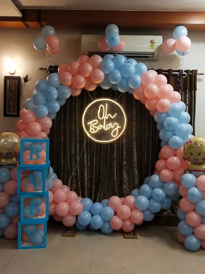 A straight-on shot of the classic pink and blue baby shower decor. The neon "Oh Baby" sign provides a modern focal point, while the balloon colors are perfect for a traditional theme or a gender reveal.