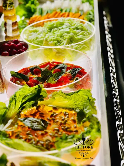 A fresh and vibrant salad bar. I offer a selection of crisp greens, fresh vegetables, and delicious dressings, providing a healthy and colorful option for guests.