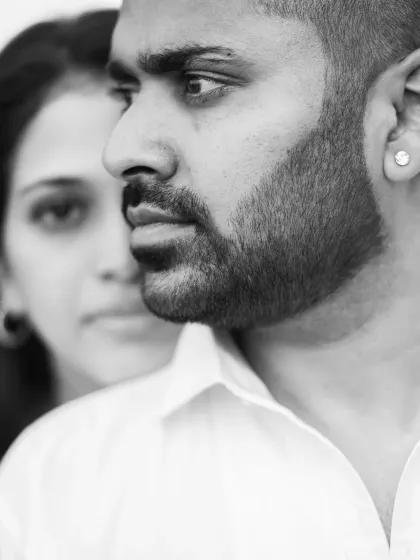 A dramatic black and white close-up from a pre-wedding shoot. This artistic portrait focuses on his strong profile, with her softly in the background, creating a sense of depth and emotion.