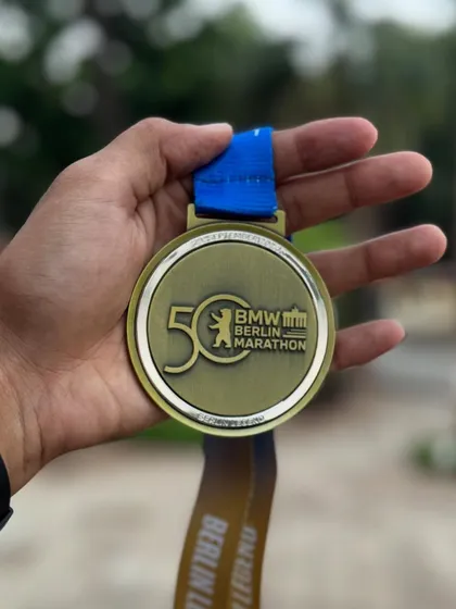 A close-up of the 50th BMW Berlin Marathon medal. A piece of history earned through sweat and dedication.