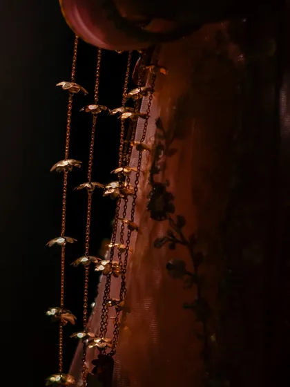 A macro shot of the delicate 'kaleerein' hanging from the bride's bangles, a beautiful and significant part of the bridal attire.
