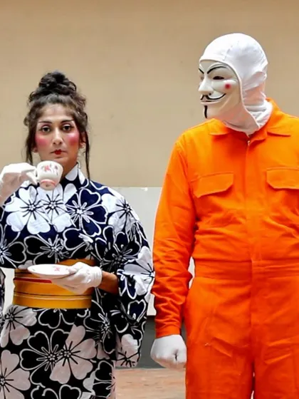 The stage allows for transformation, and in "No Strings Attached," we play with masks and identity. This moment captures the surreal and comedic nature of the show, where I embody a Japanese character in a cross-cultural dialogue.