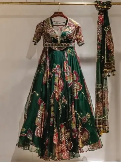 This dark green Anarkali with vibrant floral prints is a stunning choice for a Sangeet or Mehendi night. The rich color and beautiful embroidery make it a standout piece.