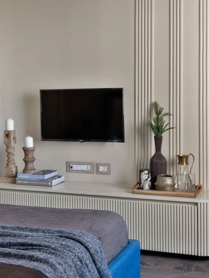 For this client who wanted a calm room, I used simple textures on the wall and a monochromatic palette. The fluted paneling on the TV unit and wall adds visual play without being overwhelming.