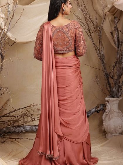 The back view of our rose-dust drape lehenga-saree, highlighting the intricate embroidery on the blouse and the elegant fall of the drape. A true statement of style.