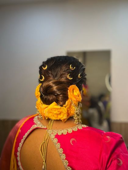 Another angle of the twisted bun with yellow roses. The twists create a beautiful texture that complements the softness of the rose petals, resulting in a fresh and youthful bridal hairstyle.