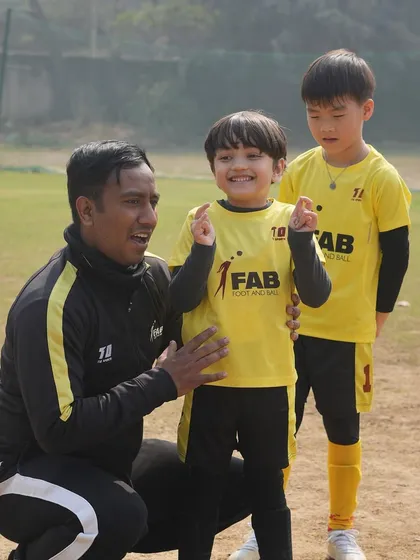 A coach celebrating with his players. We guide our players towards excellence with passion and dedication.
