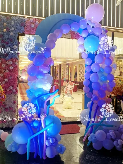 Another view of the blue-lit mermaid entrance, highlighting the intricate balloon sculptures that create a sense of movement and flow.