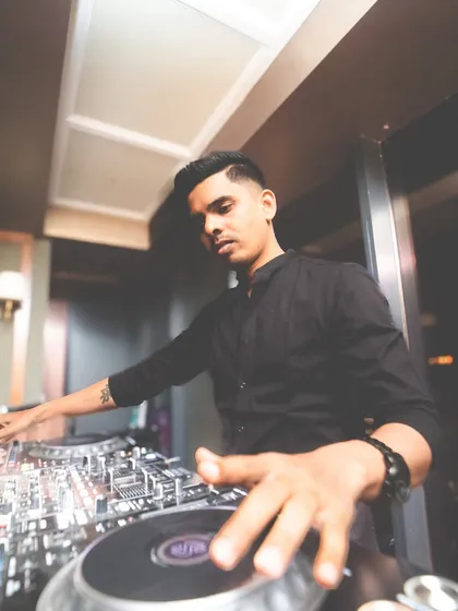 A low-angle shot showing my hands on the Pioneer DJ gear, crafting the sound for the night.