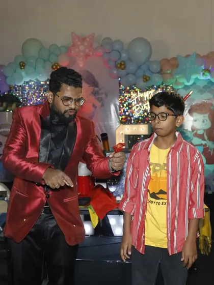 A young volunteer helps me with a classic sleight of hand trick. I love teaching kids a little bit of magic during my shows.
