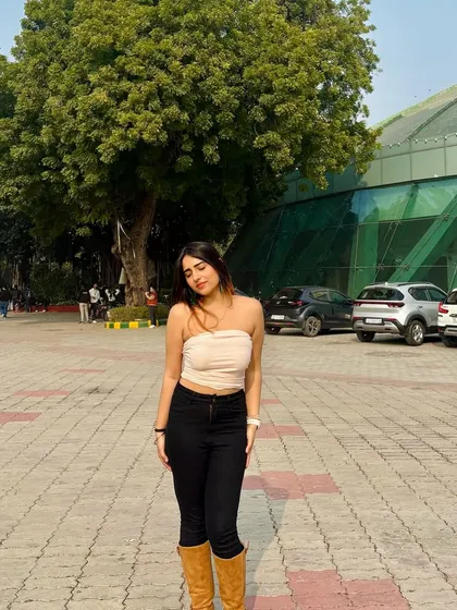 A simple yet stylish outfit with a beige tube top, black jeans, and brown boots. This is a perfect example of a transitional, fall-inspired look.