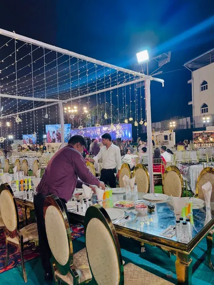 My staff making final adjustments to the table settings, ensuring everything is perfect for the guests' arrival.