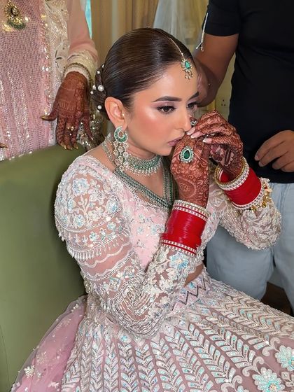 A quiet, prayer-like moment. The makeup is subtle yet polished, giving the bride a serene and angelic glow for her special day.