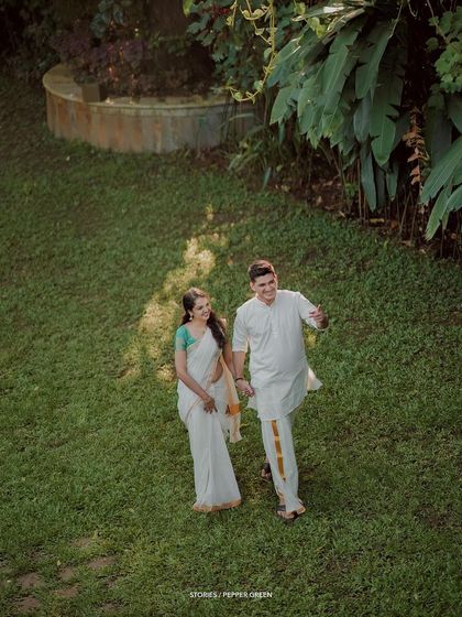 A high-angle shot of the couple walking through a garden, creating a beautiful and unique perspective.