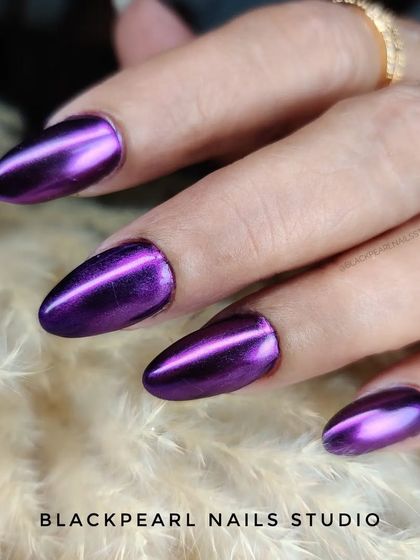 A close-up of the purple chrome nails, showing the intense, reflective shine. This effect is perfect for making a powerful and stylish statement.