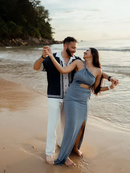 A playful dance on the wet sands of Phuket. This candid photo captures the couple's fun-loving dynamic and the beautiful coastal light, showing that a pre-wedding shoot is all about having fun together.