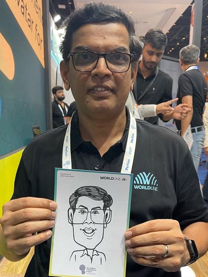 A smiling attendee from the Worldline global fintech event, holding his branded caricature.