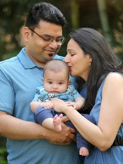 A mother's gentle kiss for her baby. Outdoor sessions provide a beautiful, relaxed backdrop for capturing these sweet, candid family moments.