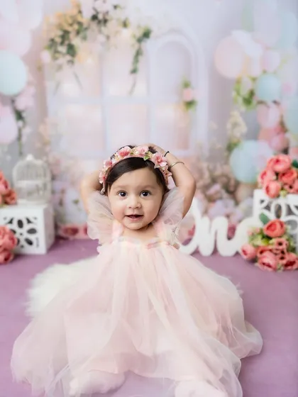 A full-width shot of this little princess in her magical, floral first birthday setup.