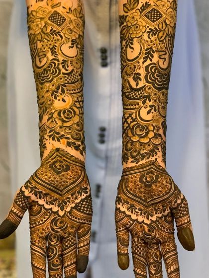 A stunning full-arm design where floral vines climb up the arms, balanced by a bold, symmetrical pattern on the palms.