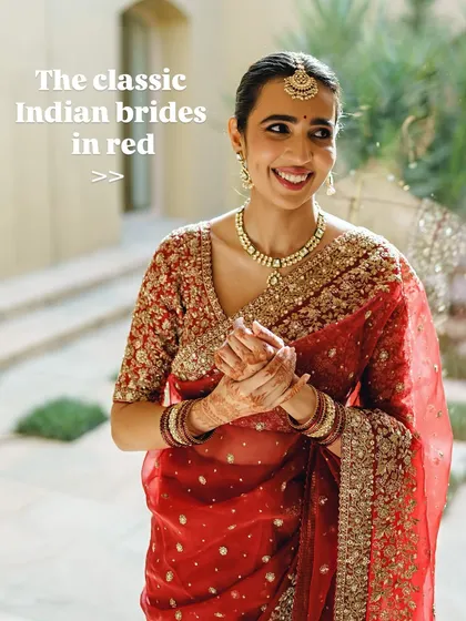 The classic Indian bride in red. Her happy, natural smile is the best accessory to her soft makeup and traditional red saree.