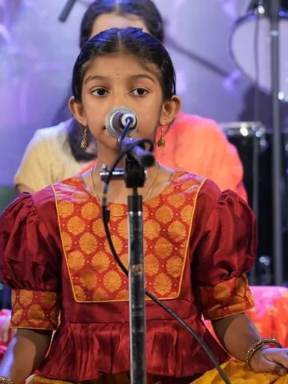 This young performer demonstrates excellent posture and focus during her group vocal performance.