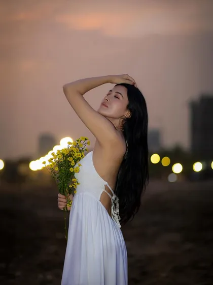 I love shooting outdoors during the golden hour. For this beach portrait, we used the soft, warm sunset light to create a serene and dreamy mood, highlighting the model's peaceful expression against the city lights.