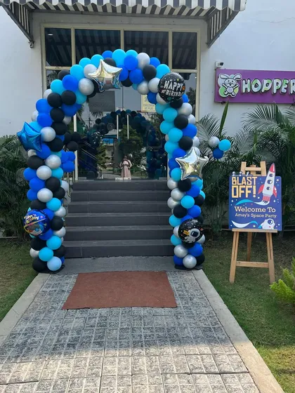 Ready for blast off with this space-themed party entrance, featuring a blue, black, and silver balloon arch.