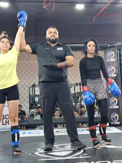 One of our female fighters stands victorious in the cage. We train women to be formidable competitors, equipped with the skills and confidence to win in striking-based combat sports.
