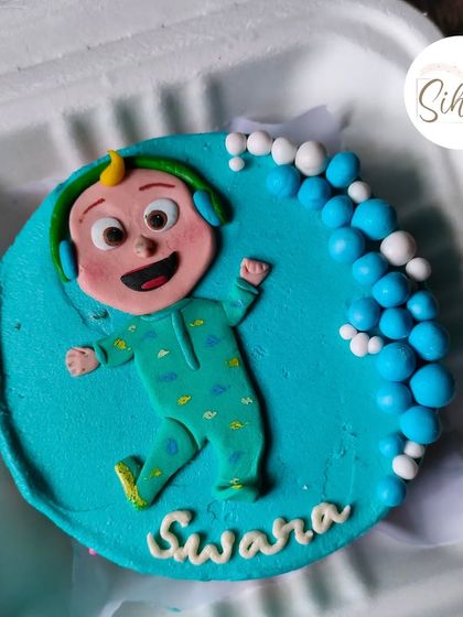 Perfect for a little one's celebration, this Cocomelon bento cake is bright and cheerful. It features a detailed fondant figure of JJ in his pajamas against a vibrant blue background.