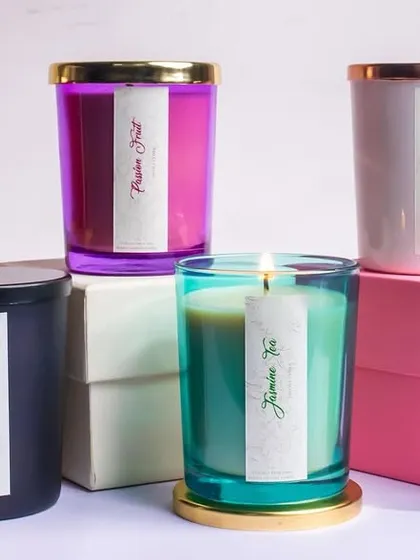 A vibrant stack of our colorful glass jar candles. Each color represents a different luxurious scent, from the spicy Apple Cinnamon to the fresh Jasmine Tea, offering a fragrance for every preference.