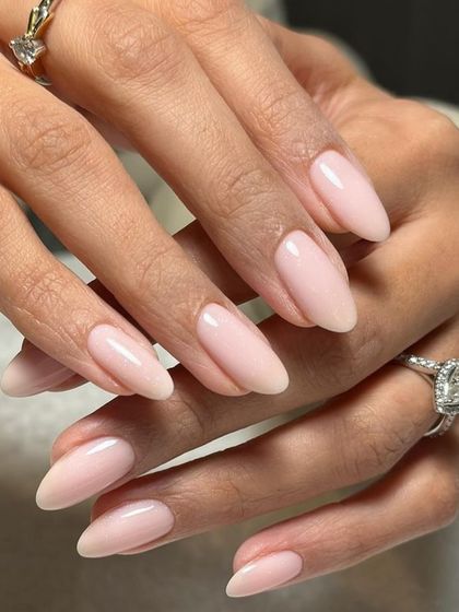 A sheer, milky pink polish on long, elegant almond nails. This is the ultimate clean, healthy, and sophisticated look.