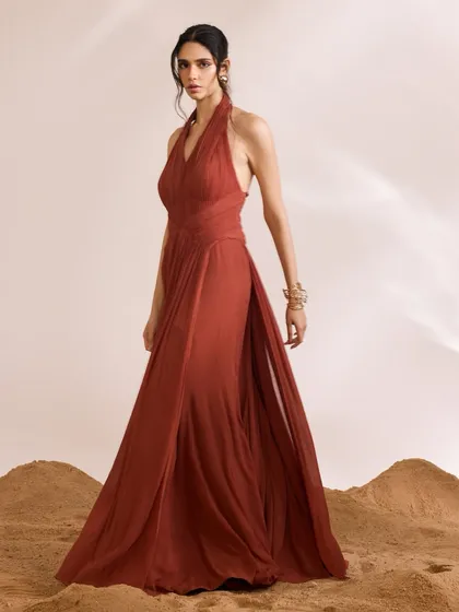 A full-length view of the Luna Dress, showcasing its flowing silhouette and halter-neck design. The intricate pleating creates a sense of contemporary sophistication.