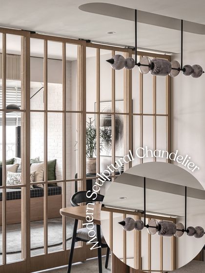 A modern sculptural chandelier made of stone-like elements hangs in this dining area. It acts as a stunning centerpiece, blurring the line between lighting and art, and is visible through the wooden grid partition.