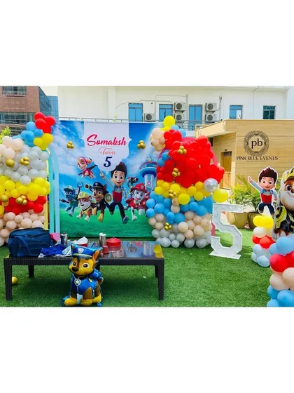 The main party area features a large themed backdrop for cake cutting, surrounded by balloon sculptures and character props. We also included a light-up number '5' to mark the special age.