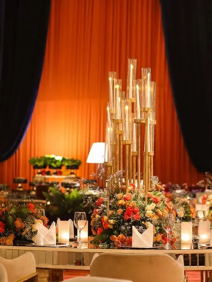 A close-up of the grand centerpiece on the main dining table, with multiple candles creating a warm and inviting glow.