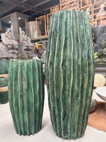 The 'Luis' planter, with its vertical ribbed texture and rich green finish, has a truly regal presence.