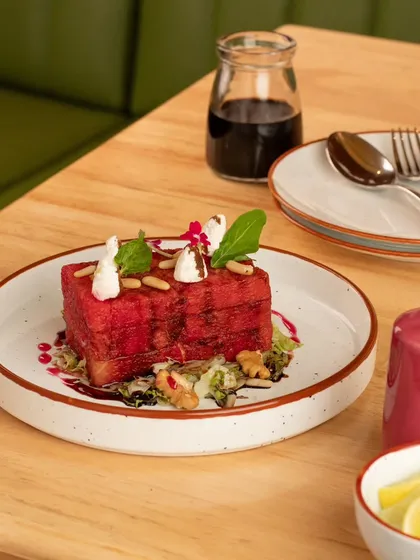 A very unique and modern take on a watermelon salad. The presentation is artistic and high-end, perfect for a fine-dining restaurant.