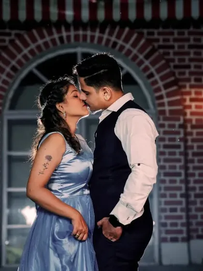 An intimate kiss silhouetted against an arched window at a pre-wedding set. This beautifully lit shot is both romantic and cinematic.