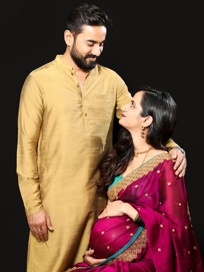 A beautiful maternity portrait celebrating Indian heritage. The mom-to-be looks radiant in her magenta saree, creating a timeless and culturally rich photograph.